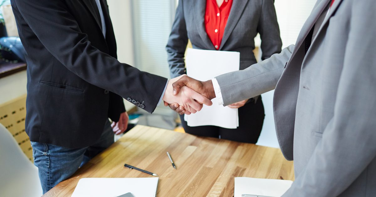 Recruitment agency fees in India illustrated by a business handshake over an agreement